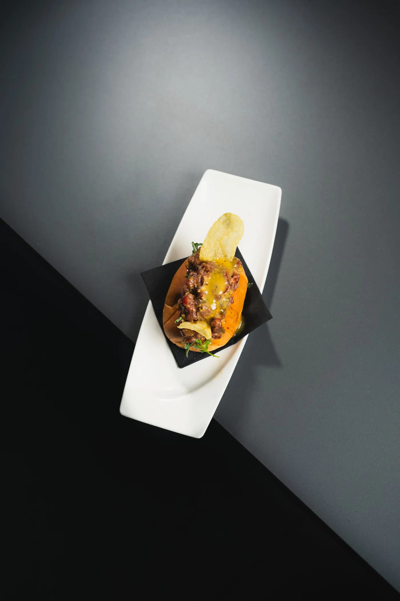 Brioche recién horneado relleno de steak tartar con emulsión de mostazas