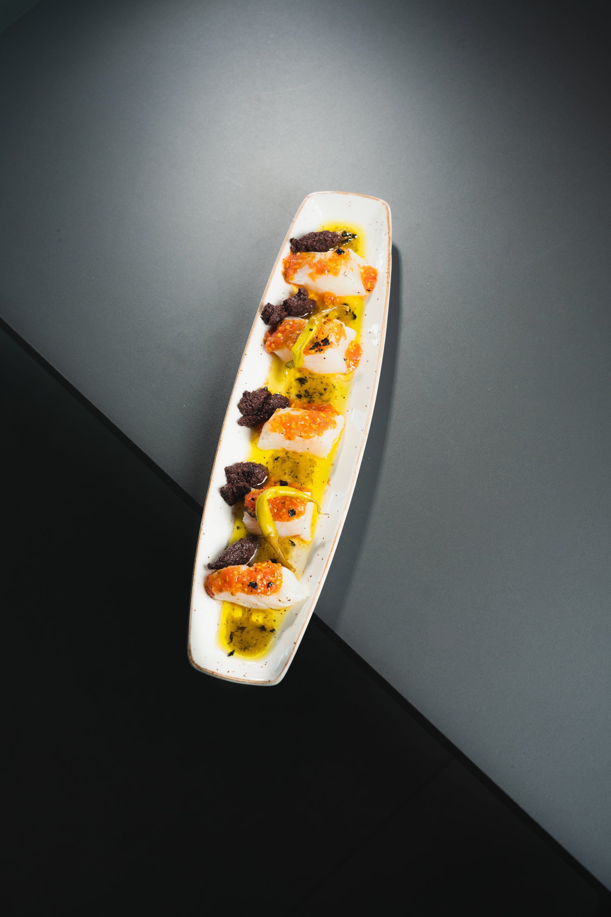 Taquitos atemperados de lomo de bacalao con pulpa de tomate y coulis de piparras rojas