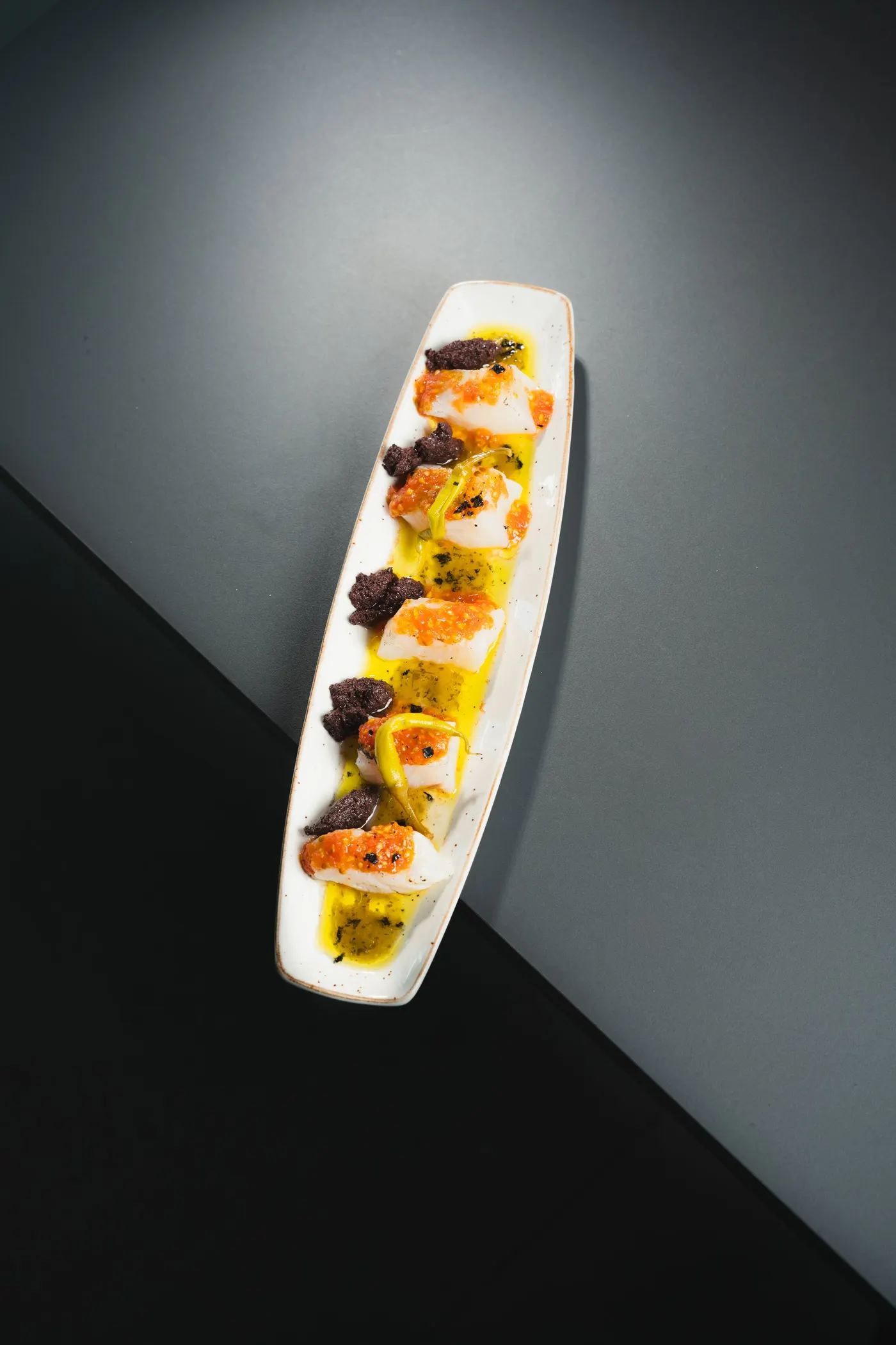 Taquitos atemperados de lomo de bacalao con pulpa de tomate y coulis de piparras rojas